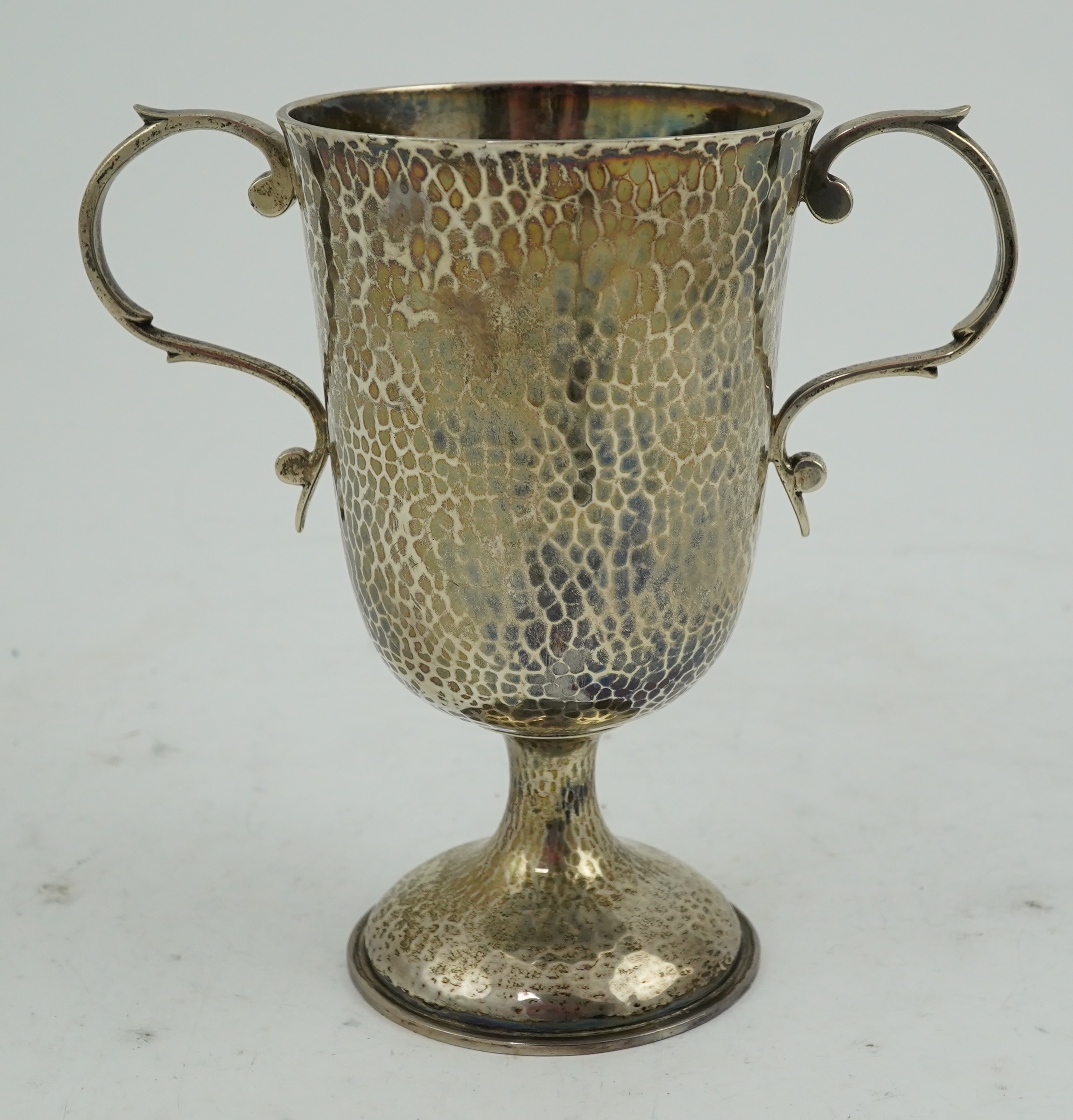 A George V planished silver two handled pedestal cup, by Henry Hodson Plante